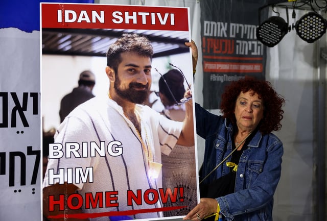 A woman holds a poster with an image of Idan Shtivi, in Tel Aviv, Israel, as hostages are released by the Palestinian militant group Hamas, amid a hostages-prisoners swap deal between Hamas and Israel, November 26, 2023. REUTERS/Athit Perawongmetha/File photo