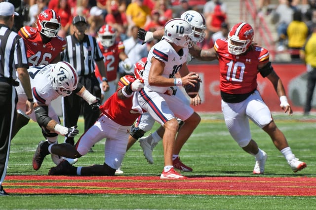 Aug 30, 2025: Maryland’s Zahir Mathis holds up Florida Atlantic quarterback Caden Veltkamp as Maryland’s Cam Rice closes in during the first half of football at SECU Stadium. (Kim Hairston/Staff)