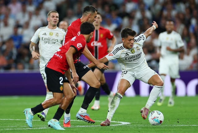 Soccer Football - LaLiga - Real Madrid v RCD Mallorca - Santiago Bernabeu, Madrid, Spain - August 30, 2025 Real Madrid's Arda Guler in action with RCD Mallorca's Martin Valjent REUTERS/Isabel Infantes