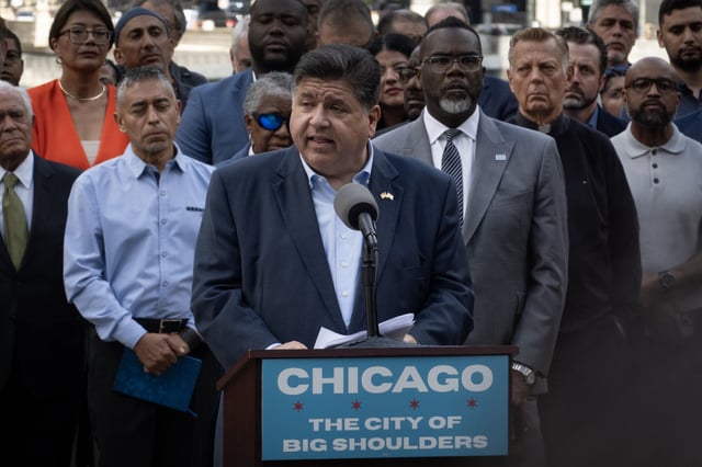 Flanked by Chicago Mayor Brandon Johnson (R), Illinois Gov. JB Pritzker speaks at a news conference with other Illinois politicians and community leaders to address President Donald Trump's plan to send National Guard troops into Chicago on August 25, 2025 in Chicago, Illinois.