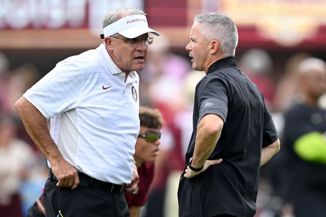 Florida State head coach Mike Norvell, right, and offensive coordinator Gus Malzahn chat on the field as players warm up before an NCAA college football game against Alabama, Saturday, Aug. 30, 2025, in Tallahassee, Fla. (AP Photo/Phelan M. Ebenhack)