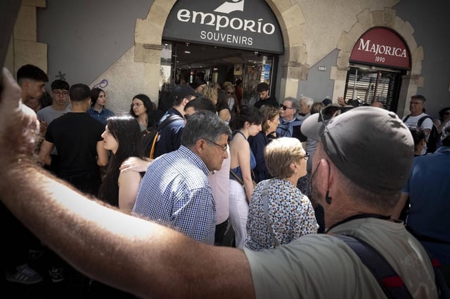 Grupos de turistas delante de una tienda de souvenirs situada frente a la Sagrada Familia de Barcelona.