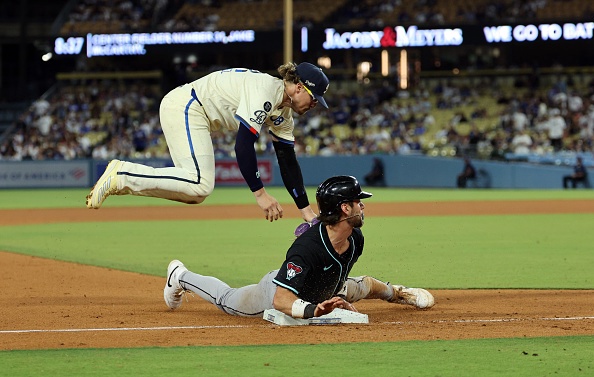 LOS ANGELES, CALIFORNIA – AUGUST 30: Blaze Alexander #9 of the Arizona Diamondbacks slids safely into third base with third baseman Enrique Hernandez #8 of the Los Angeles Dodgers attempting to tag him out on errand throw by Miguel Rojas #72 from second base during the ninth inning at Dodger Stadium on August 30, 2025 in Los Angeles, California. (Photo by Kevork Djansezian/Getty Images)