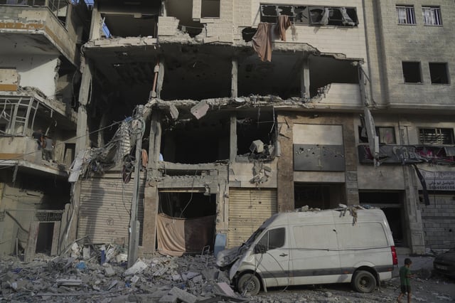 A Palestinian boy walks past a heavily damaged building in the Rimal neighborhood, in Gaza City, Sunday, Aug. 31, 2025, a day after it was hit by an Israeli military strike that killed several people. (AP Photo/Jehad Alshrafi)