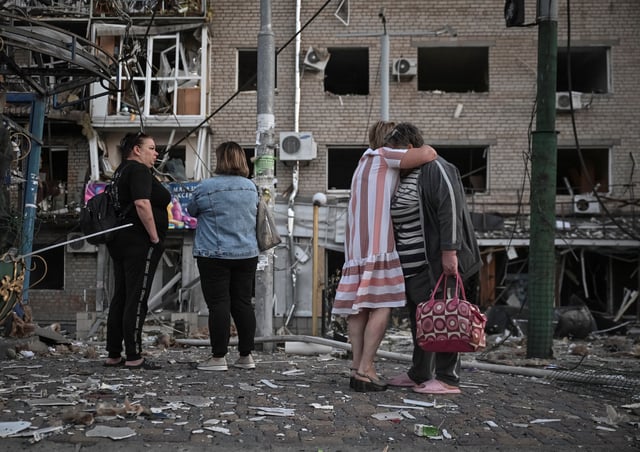 Residents stand at the site of an apartment building hit during a Russian drone and missile strike, amid Russia's attack on Ukraine, in Zaporizhzhia, Ukraine August 30, 2025. REUTERS/Stringer/File Photo