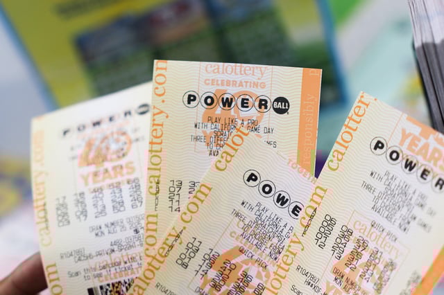 A customer holds Powerball lottery tickets for a $750 Million grand prize jackpot inside the Bluebird Liquor Store, which has sold winning tickets in past large lottery jackpots, in Hawthorne, California on August 25, 2025.