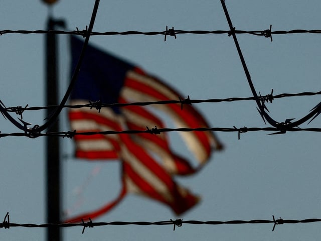 FILE PHOTO: A United States flag is seen near the El Paso airport as Guatemalan migrants, mostly shackled, are being transported to a plane to be expelled from the United States to their country of origin by agents of the U.S. Immigration and Customs Enforcement (ICE) and Border Patrol agents, at the El Paso airport, Texas, U.S., June 13, 2024. REUTERS/Jose Luis Gonzalez/File Photo