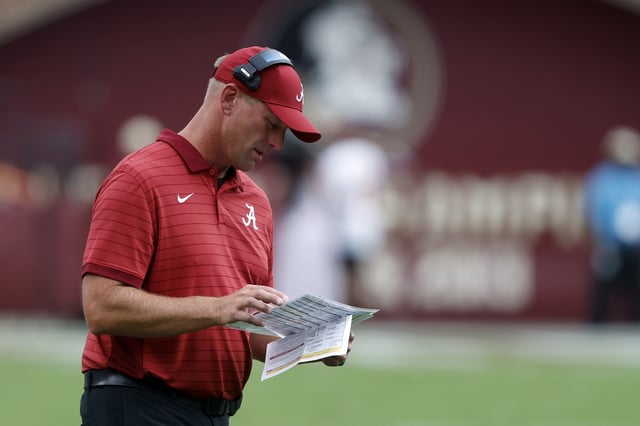 Head coach Kalen DeBoer of the Alabama Crimson Tide looks over his plays during the first quarter of a football game against the Florida State Seminoles at Doak Campbell Stadium on August 30, 2025 in Tallahassee, Florida.