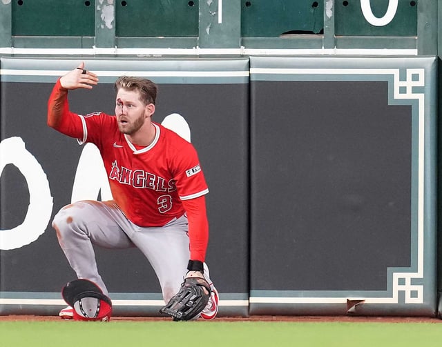 Angels outfielder Taylor Ward (3) calls for help after being injured going after a hit by the Astros Ramón Urías during the eighth inning Sunday.