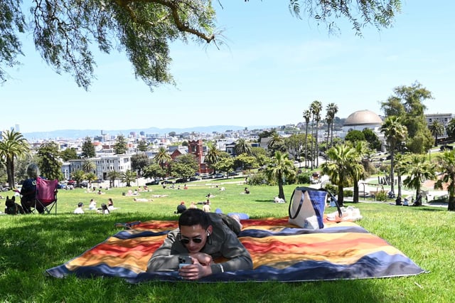 Phirung Cheng looks at his phone and listens to music at Dolores Park in San Francisco on May 9. Sunday, Aug. 31 was San Francisco's warmest day since May while Oakland, San Jose and other parts of the Bay Area experienced their hottest day since October 2024.