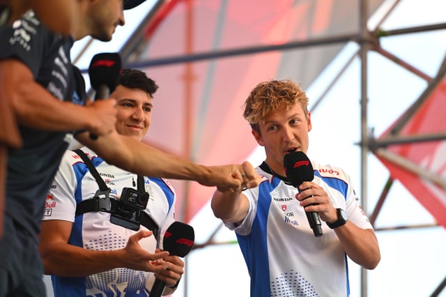 Liam Lawson of New Zealand and Visa Cash App Racing Bulls greets Carlos Sainz of Spain and Williams on the fan stage prior to practice ahead of the F1 Grand Prix of Hungary at Hungaroring on August 01, 2025 in Budapest, Hungary.
