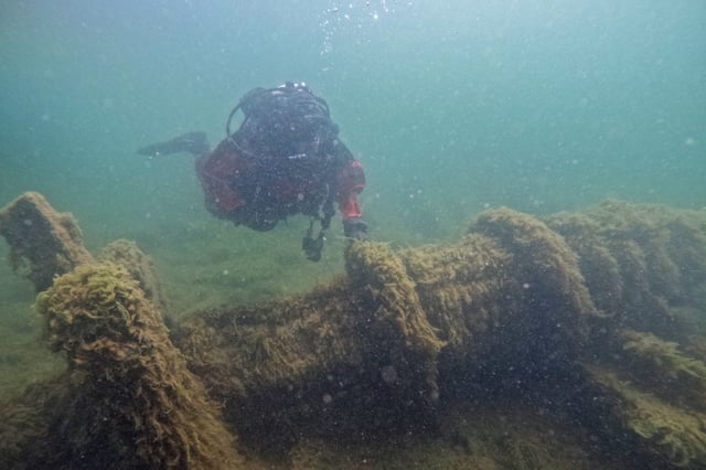 A person inspects the shipwreck.