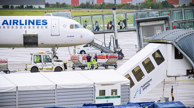 Menschen verlassen ein Flugzeug.