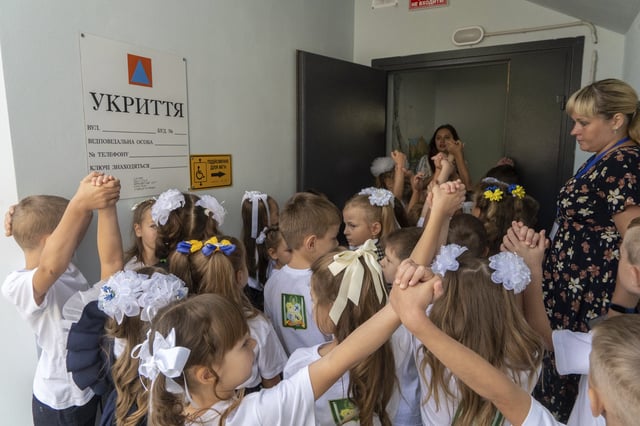 Schoolchildren enter an underground school on the first day at school in Kharkiv, Ukraine, Monday, Sept. 1, 2025. (AP Photo/Andrii Marienko)