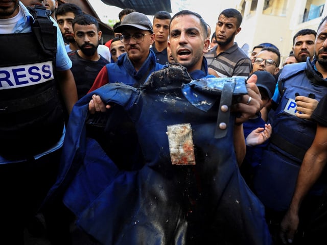 FILE PHOTO: Al Jazeera journalist Anas Al Sharif, who was killed in an Israeli strike on August 10, 2025, holds the flak jacket of his colleague Al Jazeera reporter Ismail al-Ghoul, who also was killed in an Israeli strike on July 31, 2024, during al-Ghoul's funeral in Gaza City July 31, 2024. REUTERS/Dawoud Abu Alkas/File Photo     TPX IMAGES OF THE DAY