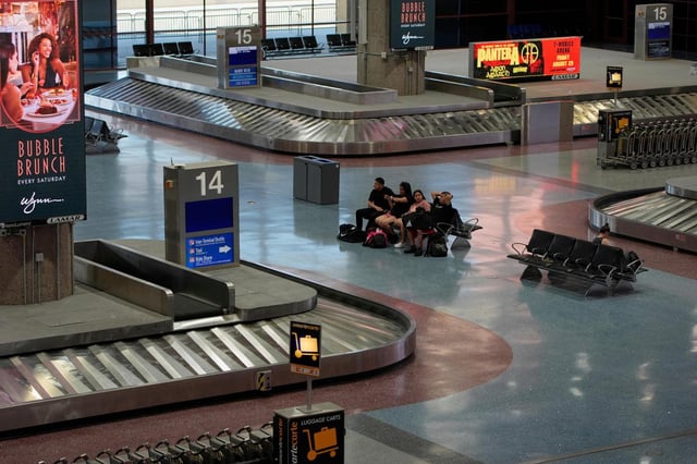 Personas esperan en la zona de entrega de equipaje del Aeropuerto Internacional Harry Reid, el viernes 29 de agosto de 2025, en Las Vegas. (AP Foto/John Locher)