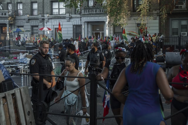 People flee the scene of a double shooting during the West Indian Day Parade on Monday, Sept. 1, 2025, in the Brooklyn borough of New York.