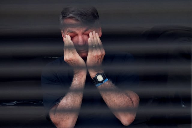 Brazil's former President Jair Bolsonaro covers his eyes at his home while under house arrest, ordered by Supreme Court Justice Alexandre de Moraes, as he awaits trial over an alleged plot to overturn the 2022 election, in Bras?lia, Brazil, August 14, 2025. REUTERS/Adriano Machado/File Photo