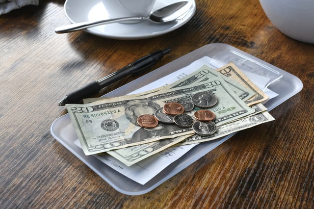 Stock image/file photo: Cash tip left on a bill in a cafe.