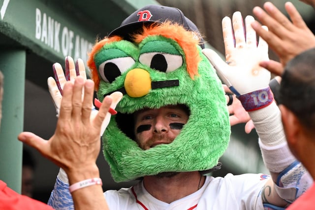BOSTON, MASSACHUSETTS - SEPTEMBER 01: Trevor Story #10 of the Boston Red Sox celebrates with his teammates wearing a mascot mask after hitting a solo home run against the Cleveland Guardians during the sixth inning at Fenway Park on September 01, 2025 in Boston, Massachusetts.