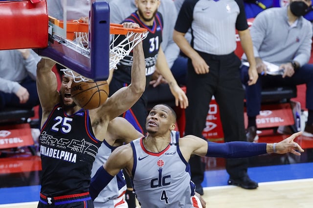 Ben Simmons #25 of the Philadelphia 76ers dunks over Russell Westbrook #4 of the Washington Wizards during Game Two of the Eastern Conference first round series at Wells Fargo Center on May 26, 2021 in Philadelphia, Pennsylvania. The Wells Fargo Center permanently banned a fan after they threw popcorn on Westbrook after he left the arena due to an injury.