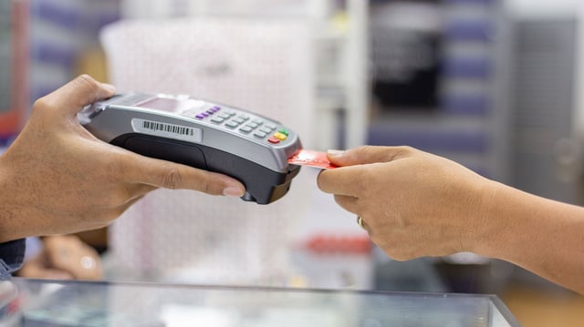 Person steckt Girocard in Kartenlesegerät