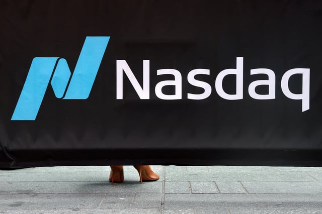 A person wearing high heels stands behind a Nasdaq banner in New York City, U.S., July 23, 2025. REUTERS/Kylie Cooper/ File Photo