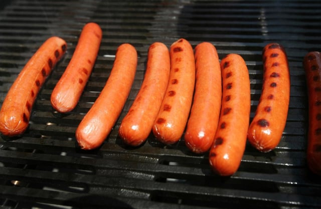 FILE – Hot dogs cook on a grill in New York’s Times Square, June 10, 2008. (AP Photo/Mark Lennihan, File)