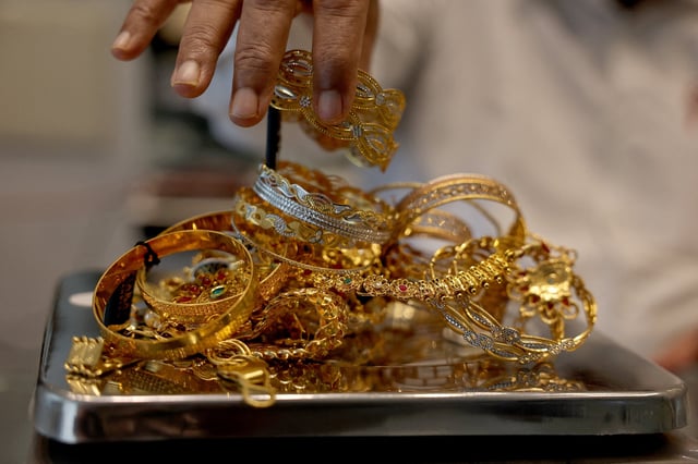 A goldsmith weighs gold jewellery inside a showroom in Ahmedabad, India, July 31, 2025. REUTERS/Amit Dave/File Photo