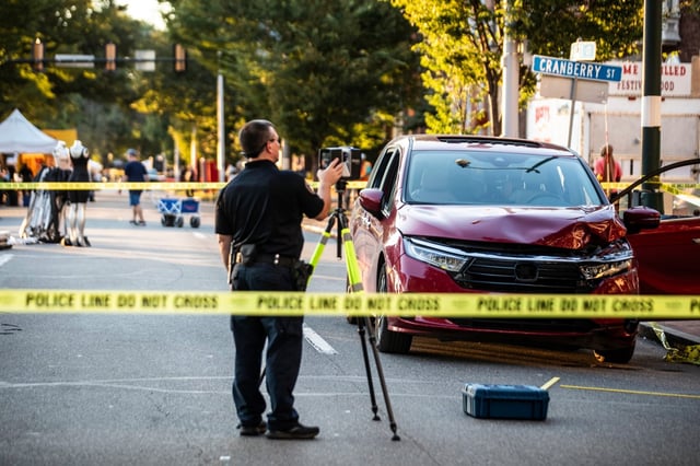 A first responder inspects the scene where a minivan crashed into a crowd at the Harrisburg Kipona Festival, Monday, Sept. 1, 2025, in Harrisburg, Pa. (Sean Simmers/The Patriot-News via AP)