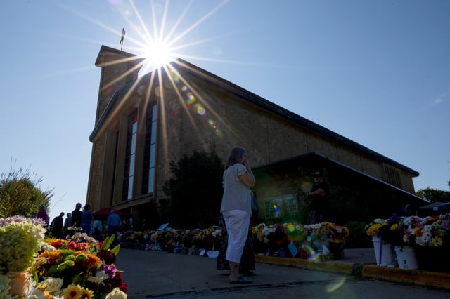 The sun shines over the memorial outside Annunciation Catholic Church during Mass after Wednesday's shooting, Sunday, Aug. 31, 2025, in Minneapolis.(AP Photo/Ellen Schmidt)