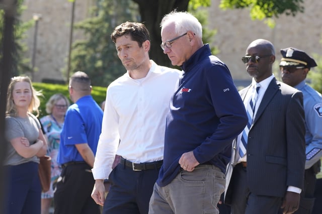 Minnesota Gov. Tim Walz, right, walks with Minneapolis Mayor Jacob Frey outside the Annunciation Catholic School following a shooting Wednesday, Aug. 27, 2025, in Minneapolis. (AP Photo/Bruce Kluckhohn)