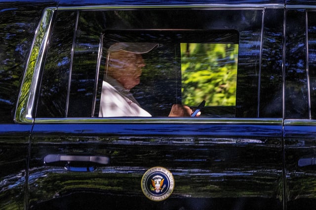 President Donald Trump checks his phone while in Washington, DC, on Sunday.