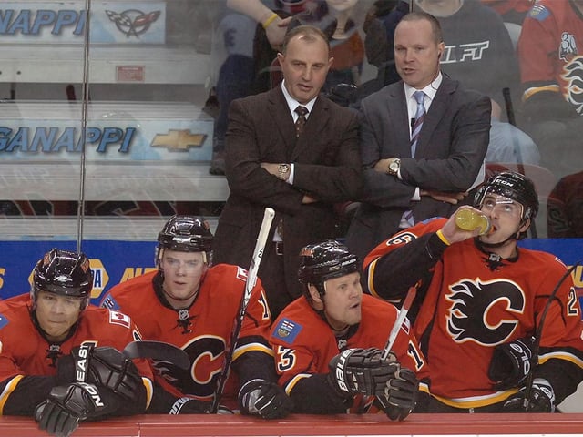 Coach Brent Sutter (L) chats with his assistant Dave Lowry from the Calgary Flames as they play the New York Islanders in NHL action at the Scotiabank Saddledome in Calgary on Jan. 3, 2011.