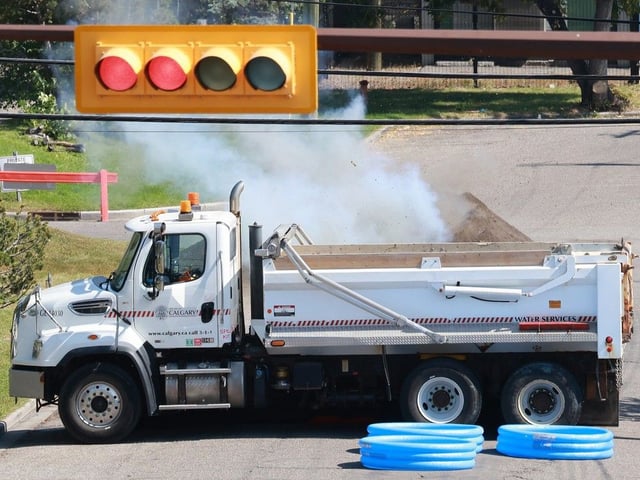 A dump truck and an earth berm contain a controlled detonation of explosive materials in the 4700 block of 1st Street S.W. on Wednesday, Aug. 27, 2025. The materials were originally delivered on Tuesday morning.