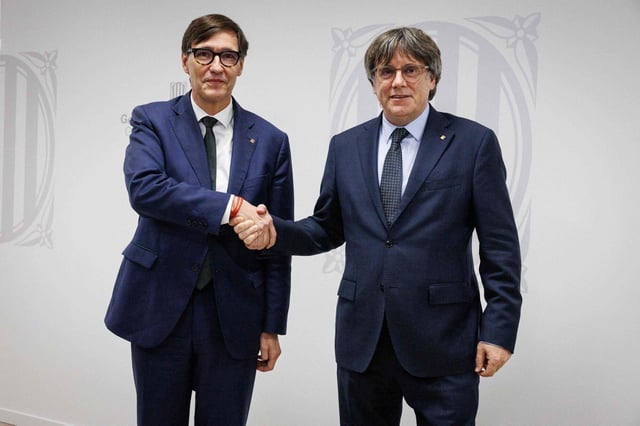 El presidente catalán Salvador Illa y Carles Puigdemont se saludan en la Delegación de la Generalitat en Bruselas, 2 de septiembre de 2025