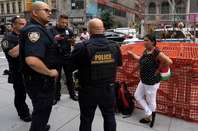 A migrant woman speaks with Homeland Security agents about how to self deport, after her husband was detained by Immigration and Customs Enforcement (ICE), in New York City, U.S., August 14, 2025. REUTERS/David 'Dee' Delgado/File Photo
