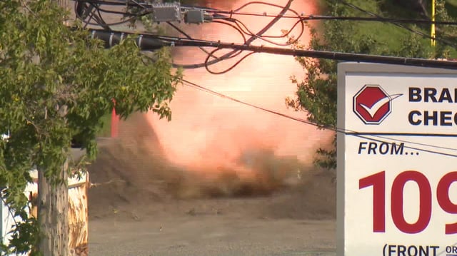 Flames and smoke can be seen rising from behind a gravel berm after the CPS bomb squad conducted a controlled explosion of some dangerous chemicals that forced the evacuation of several city blocks in Calgary's Manchester industrial district on Tuesday, Aug. 27, 20025.