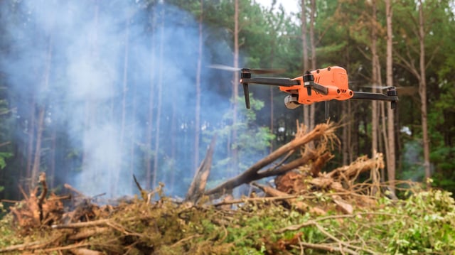 In the forest, fire services are using a drone to follow the fire into the trees