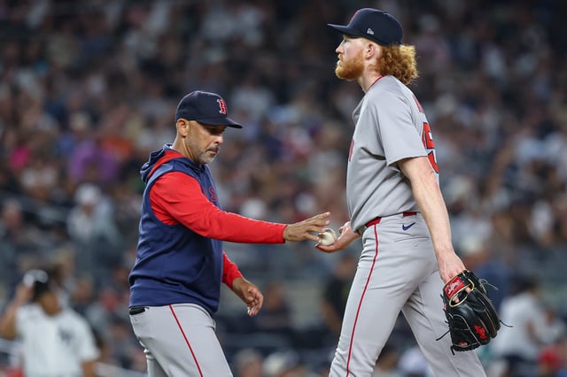 NEW YORK, NEW YORK - AUGUST 24: Dustin May #85 of the Boston Red Sox hands the ball to manager Alex Cora #13 during the game against the New York Yankees at Yankee Stadium on August 24, 2025 in New York City.