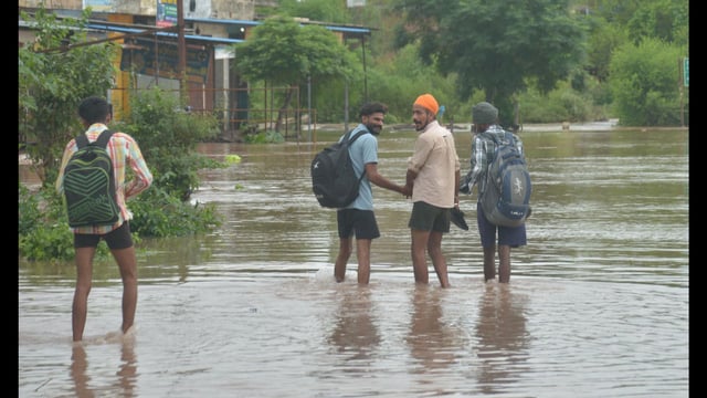 Locals wade through a flooded street at a village near Ajnala in Amritsar on Tuesday. (Sameer Sehgal/HT)