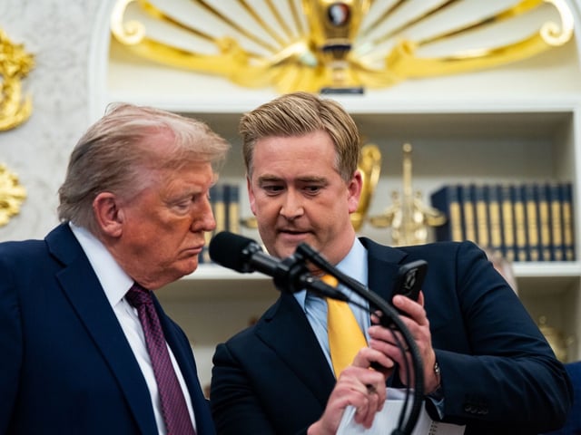 Peter Doocy, White House correspondent for FOX News, shows US President Donald Trump a video on his phone during an announcement in the Oval Office of the White House in Washington, DC, US, on Tuesday, Sept. 2, 2025. Trump announced he's bringing the headquarters of the US Space Command back to Alabama, reversing a Biden administration move and capping a political back-and-forth after a push by the state's Republican congressional delegation. Photographer: Al Drago/Bloomberg