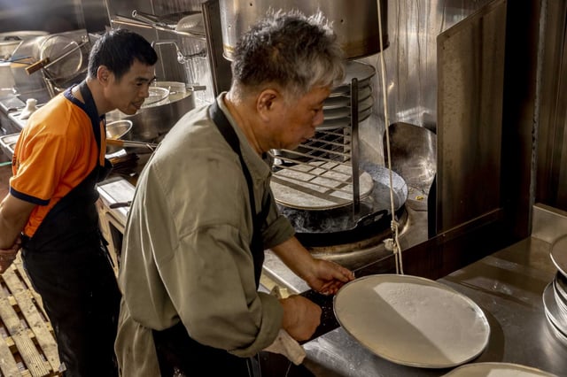 David Ho, former co-owner and chef of Sam Wo, prepares a rice roll in San Francisco, Tuesday, Sept. 2, 2025. The 116-year-old landmark is set to return under new ownership this Friday, September 5. The restaurants’ new chef has been training with Ho for two weeks, learning how to make Sam Wo’s famous rice rolls from scratch and other dishes.