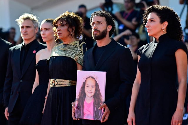 De izquierda a derecha: el actor estadounidense Joaquin Phoenix, la actriz estadounidense Rooney Mara, el director tunecino Kaouther Ben Hania, el actor Motaz Malhees y la actriz Clara Khoury posan con un retrato de la fallecida niña palestina Hind Rajab durante la alfombra roja de la película "The Voice of Hind Rajab", en el 82º Festival Internacional de Cine de Venecia