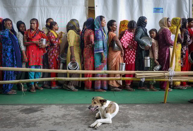 Flood-affected people wait in line to receive free food, distributed at a transit camp, after the water level of river Yamuna rose due to heavy monsoon rains, in New Delhi, India, September 3, 2025. REUTERS/Bhawika Chhabra