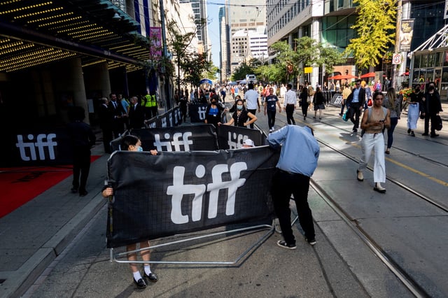 People move a sign along King Street West at the Toronto International Film Festival (TIFF) in Toronto, Ontario, Canada September 8, 2022. REUTERS/Carlos Osorio/ File Photo