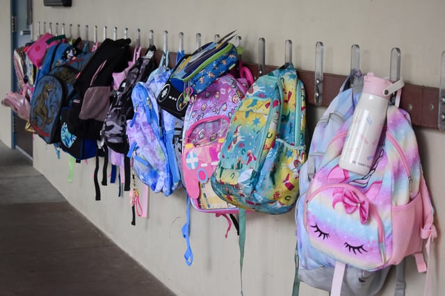 Backpacks hang outside a classroom at Gabriela Mistral Elementary School on the first day of school on Aug. 13, 2025. Photo by Zoe Morgan.