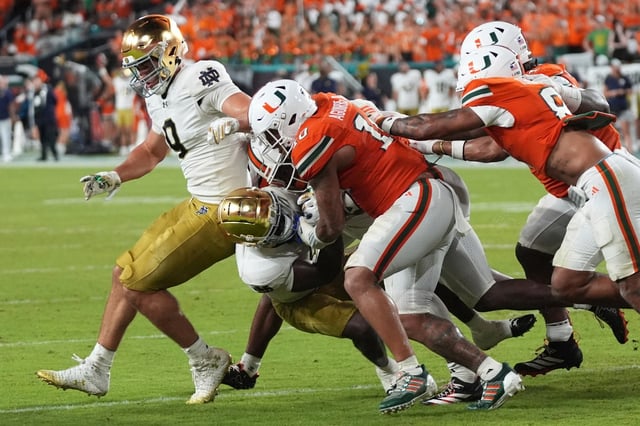 Miami linebacker Raul Aguirre Jr. (10) defends Notre Dame running back Jeremiyah Love, second from left, during the second half of an NCAA college football game, Sunday, Aug. 31, 2025, in Miami Gardens, Fla. (AP Photo/Lynne Sladky)