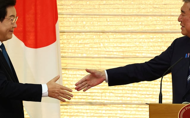 South Korea's President Lee Jae Myung and  Japan's Prime Minister Shigeru Ishiba reach out to shake hands at joint press announcement after the summit in Tokyo, Japan, August 23, 2025. REUTERS/Kim Kyung-Hoon/Pool/File Photo