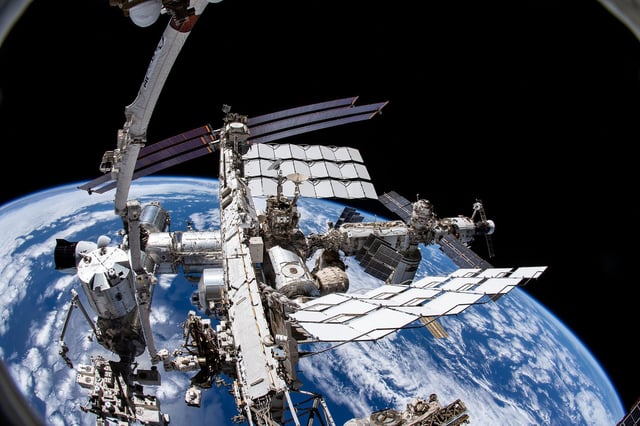iss066e085461 (Dec. 2, 2021) --- This view from NASA spacewalker Thomas Marshburn's camera points downward toward the International Space Station with the Earth 265 miles below him. Marshburn was attached to the Canadarm2 robotic arm during a six-hour and 32 minute spacewalk to replace a failed antenna system on the orbiting lab's Port-1 truss structure.